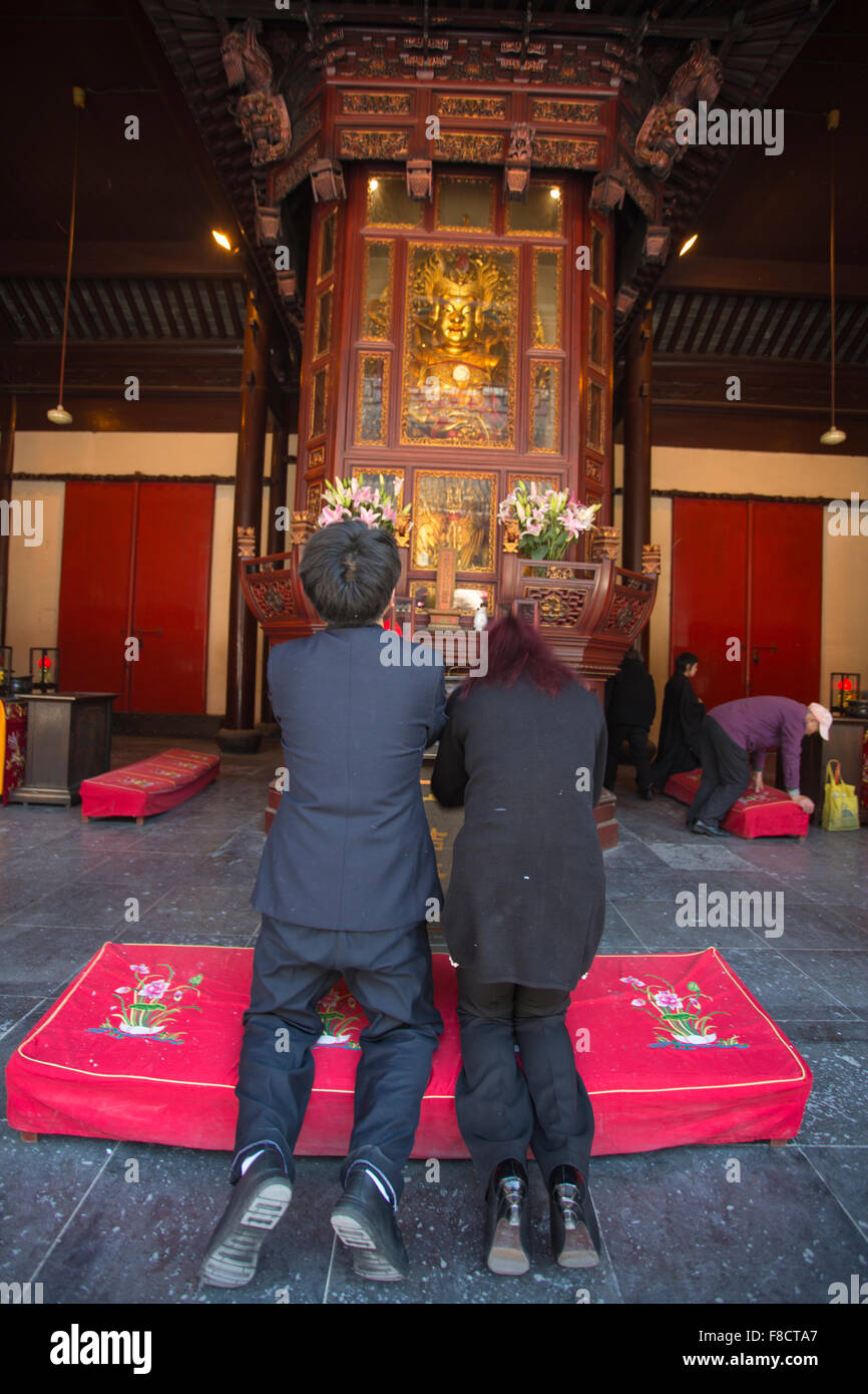 Due persone in preghiera in un tempio di Shanghai Foto Stock