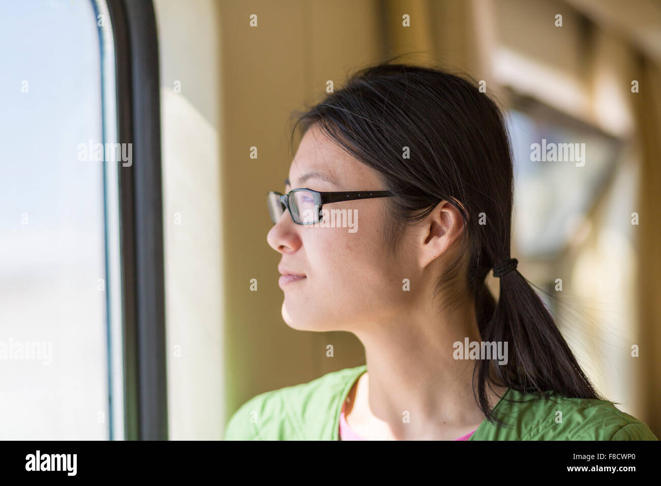 Bella Donna che guarda attraverso la finestra di un treno Foto Stock