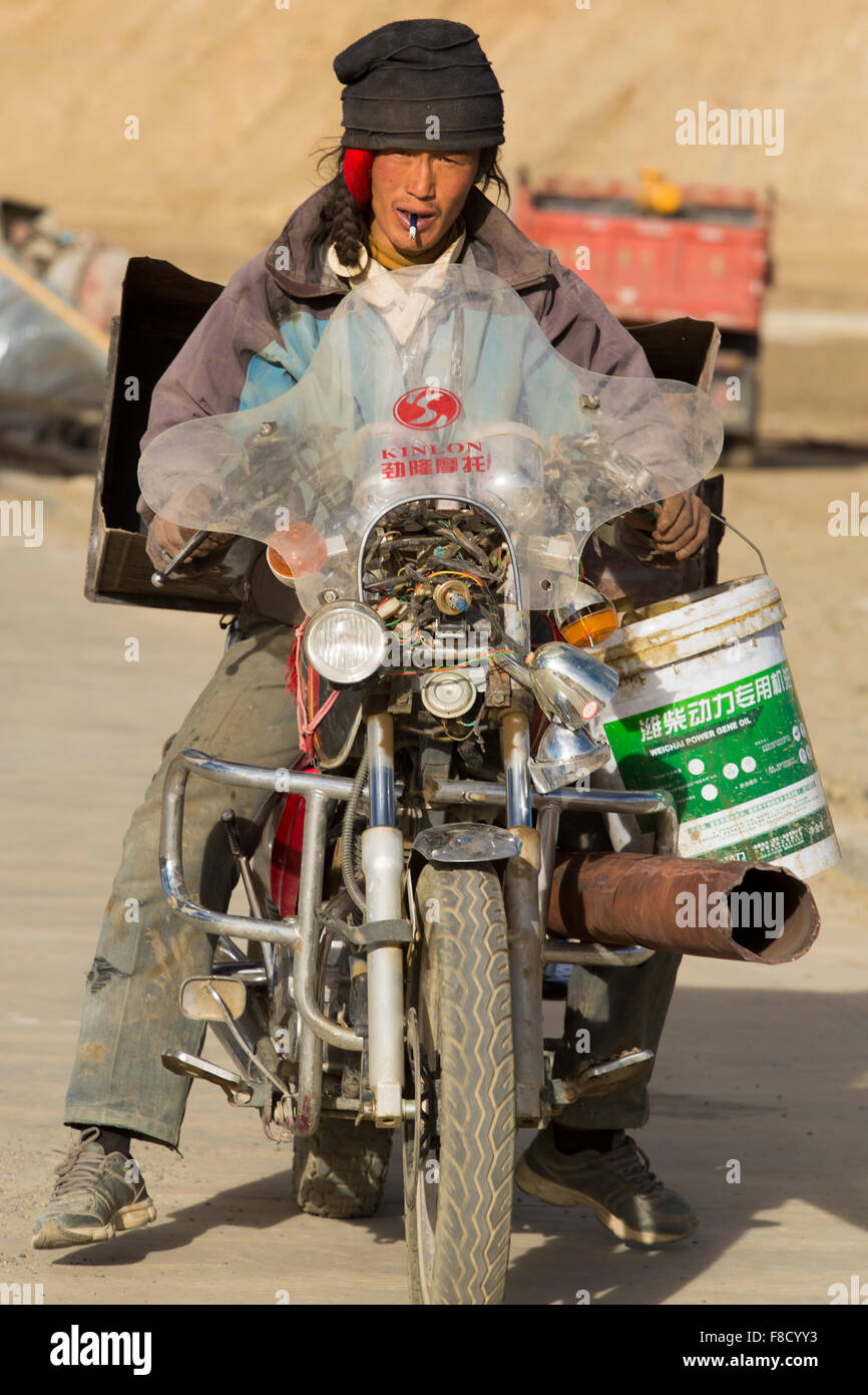 Il Tibetano lavoratore alla guida di una rotta locale moto cinesi in Tibet  Foto stock - Alamy