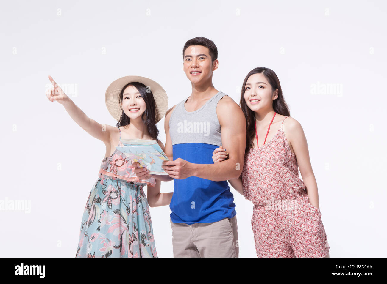 Due maschi e femmine di turisti insieme con una mappa e una donna puntato da qualche parte con le sue dita Foto Stock