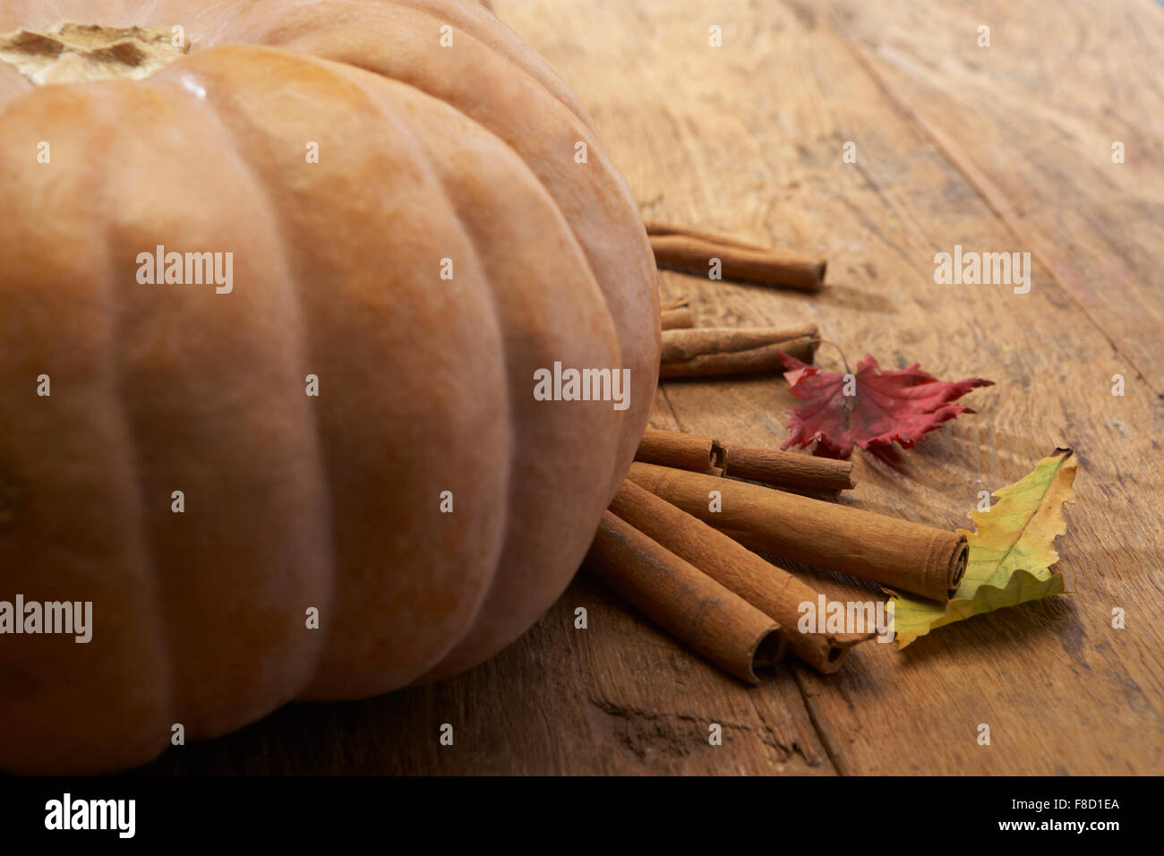 Di zucca e cannella con caduta foglie sul pavimento in legno Foto Stock