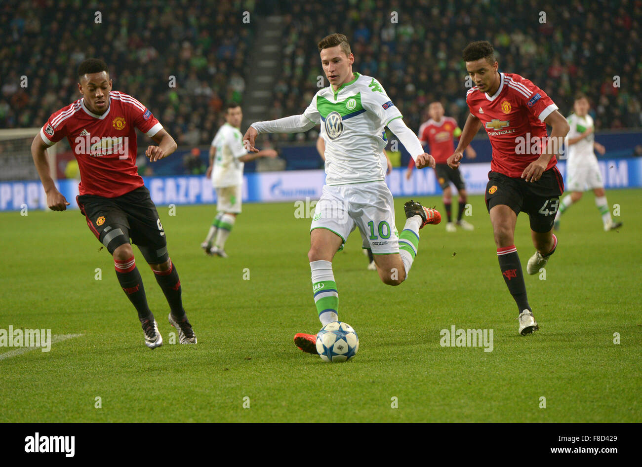 Wolfsburg, Germania. 08 Dic, 2015. Wolfsburg il giocatore di calcio Julian Draxler (C) e Manchester Anthony Martial (L) e Cameron Borthwick-Jackson lotta per la palla durante la UEFA Champions League Soccer match tra VfL Wolfsburg e il Manchester United all'Arena di Wolfsburg, Germania, 08 dicembre 2015. Foto: Peter Steffen/dpa/Alamy Live News Foto Stock