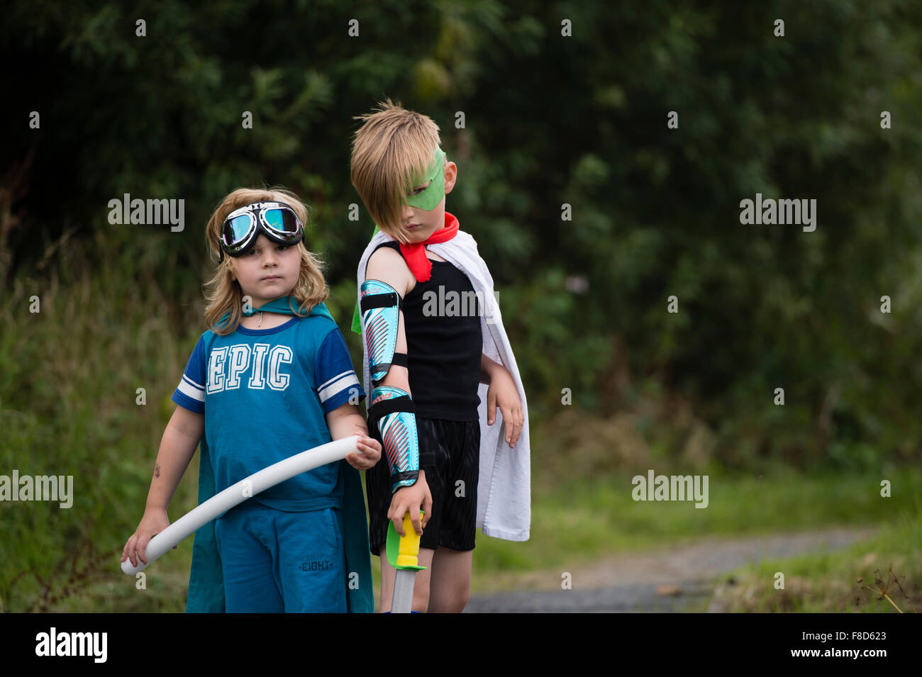 Due ragazzi in home fatto costumi vestito e giocare all'aperto presso essendo Mini supereroi su una sera d'estate , REGNO UNITO Foto Stock