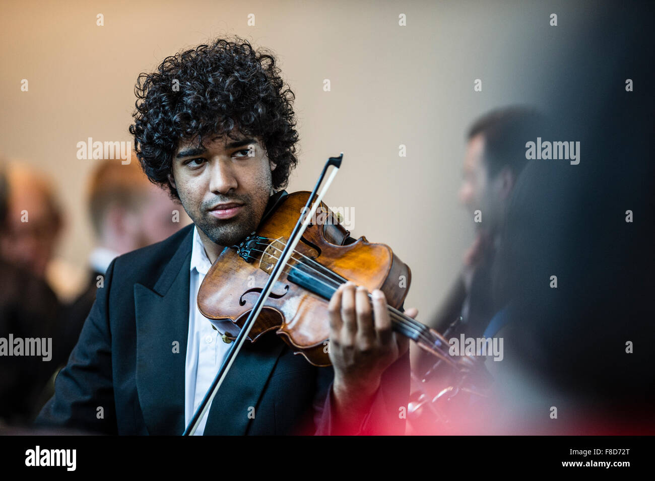 Giovani musicisti: un maschio di musica classica violin player nell'Orchestra Orion tuning up prima di eseguire a Aberystwyth Music Fest Festival 2015 Foto Stock