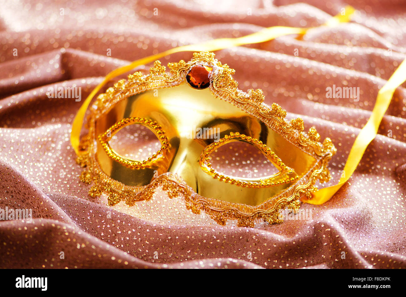 Maschera d'oro su sfondo satinato Foto Stock