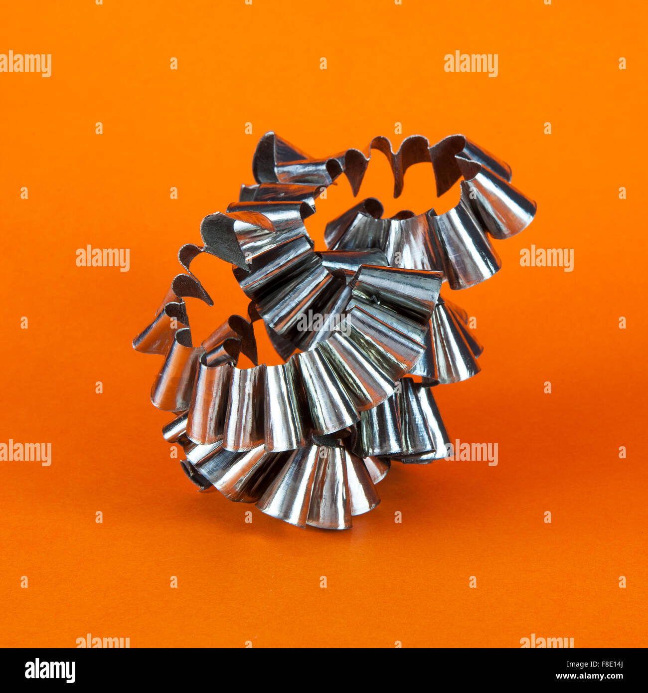 Presenza di limatura metallica su sfondo arancione Foto Stock