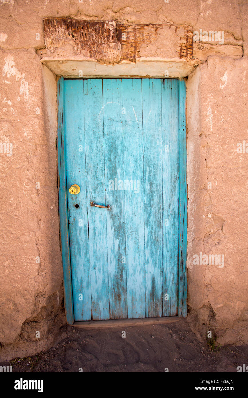 Vecchio sbiadito in legno porta coloniale e adobe architettura in un piccolo villaggio in Potosi Stato. Bolivia Foto Stock