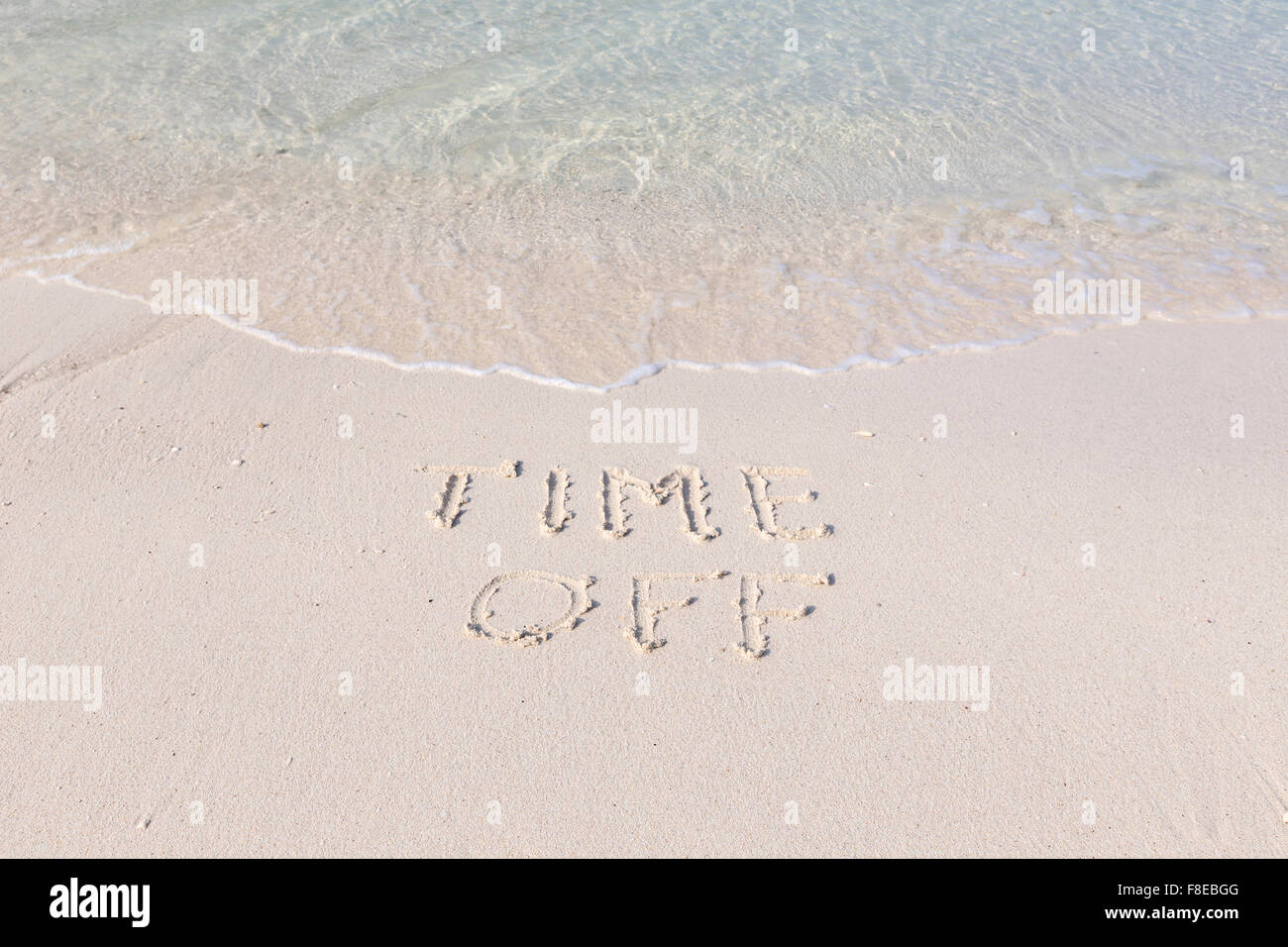 Tempo di spegnimento scritta in sabbia bagnata su una spiaggia tropicale Foto Stock