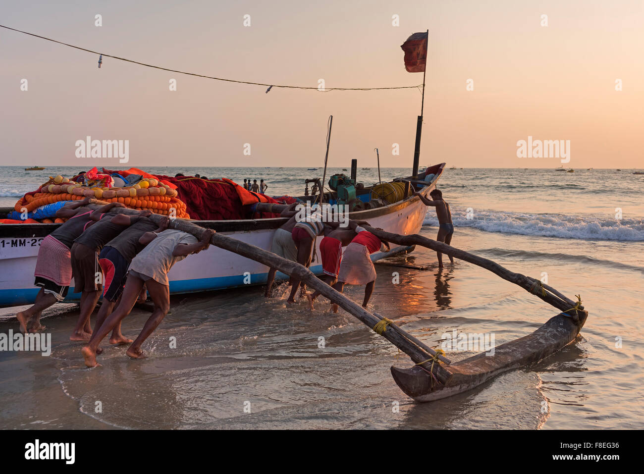 I pescatori lanciando la loro barca Colva Beach Goa in India Foto Stock