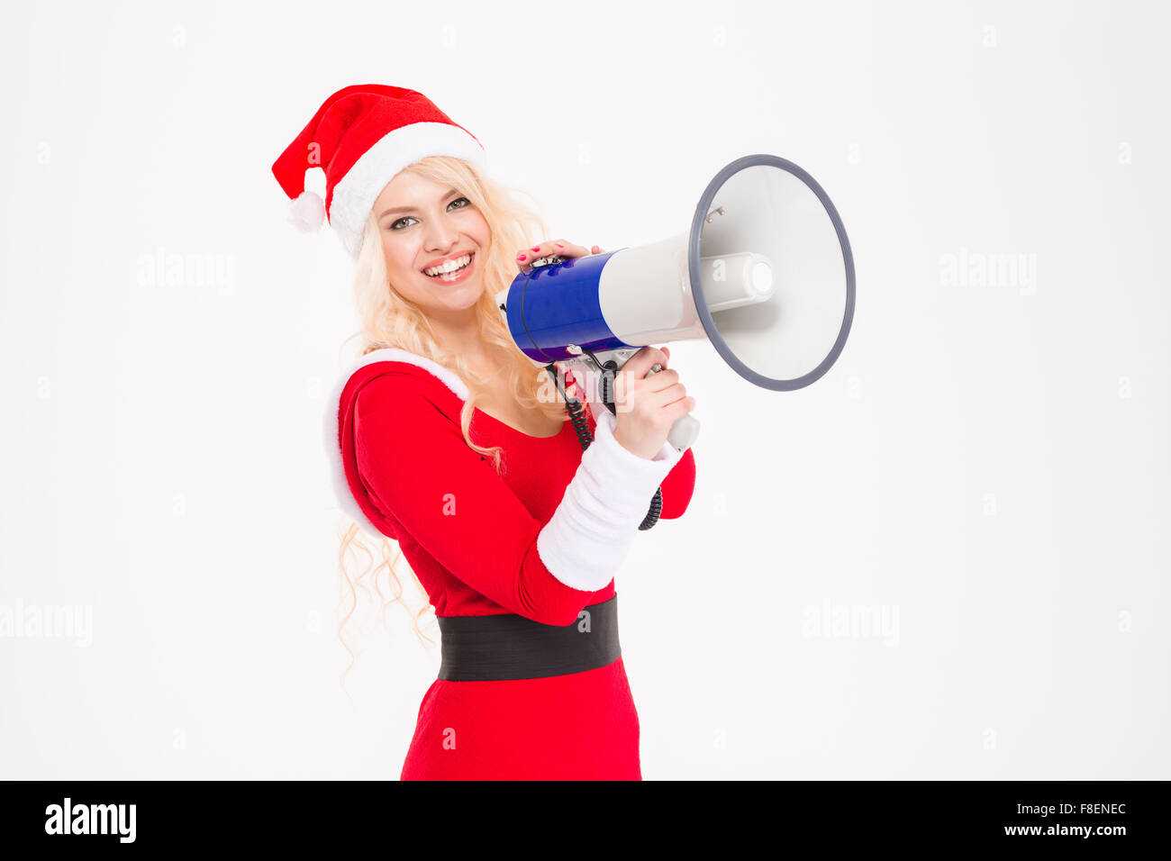 Ritratto di bella felice giovane donna in santa claus i vestiti e il cappello con megafono isolate su sfondo bianco Foto Stock