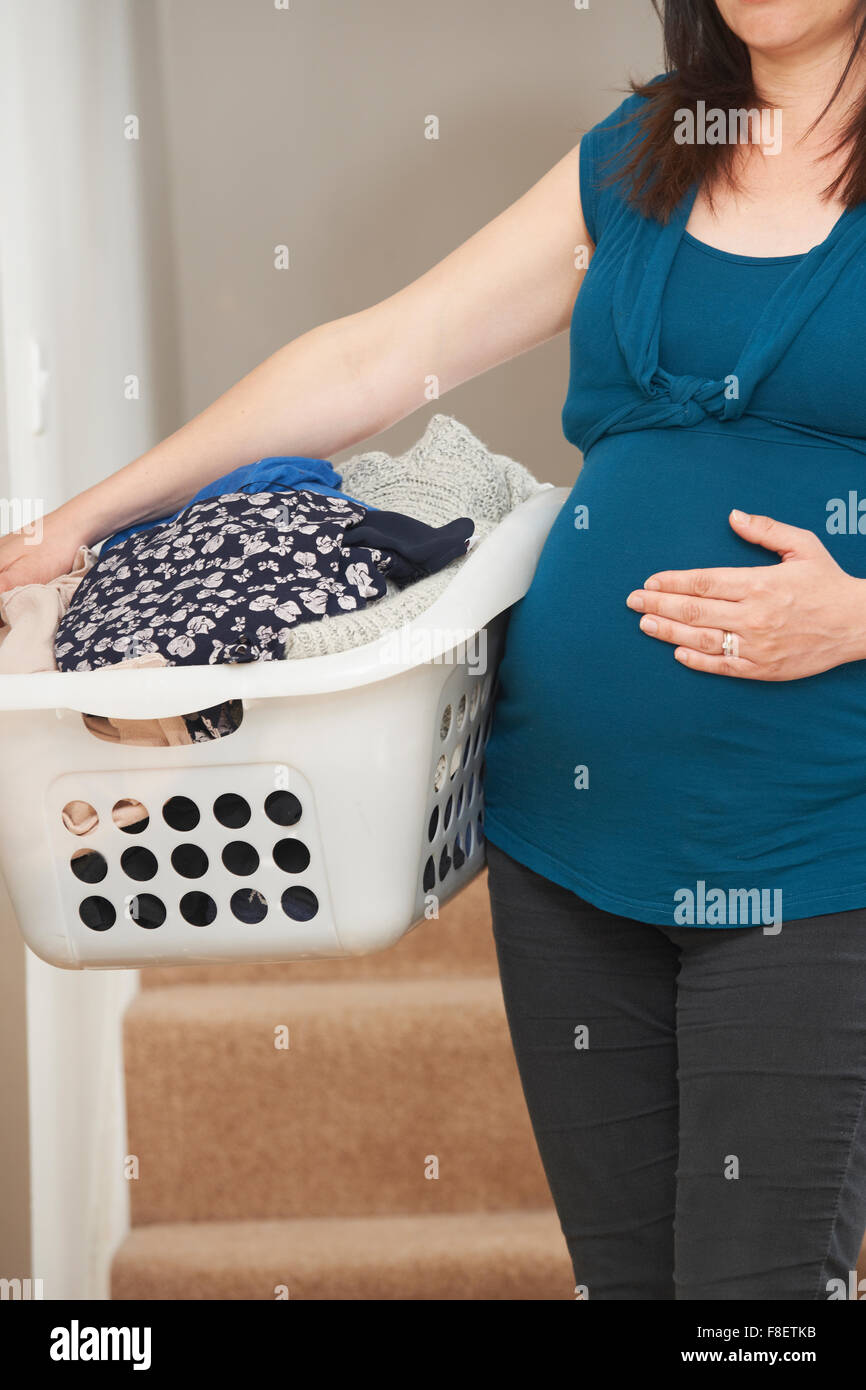 Donna incinta facendo faccende di casa Foto Stock
