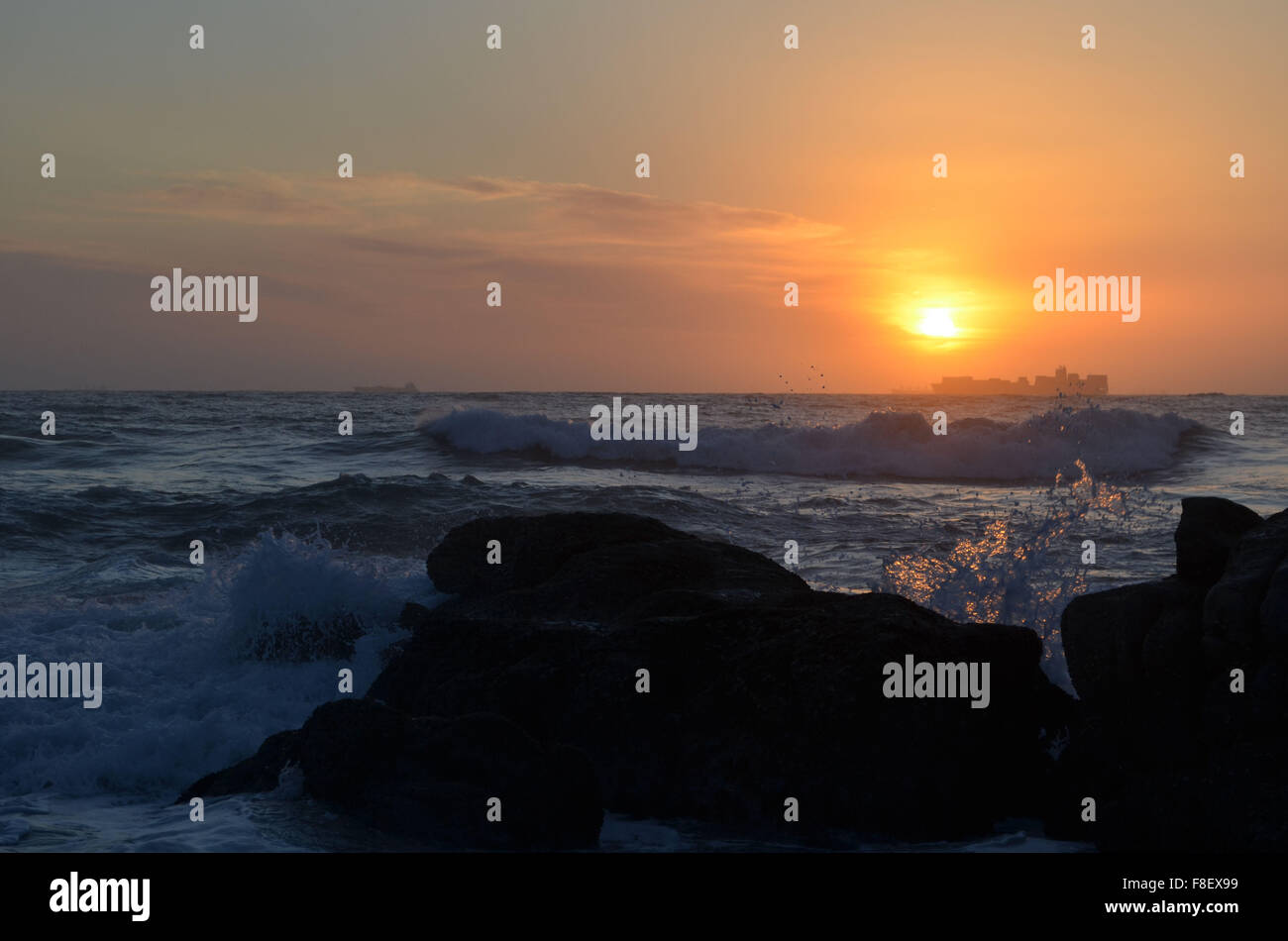Sunrise dietro la nave con acqua splash in colori di rame Foto Stock