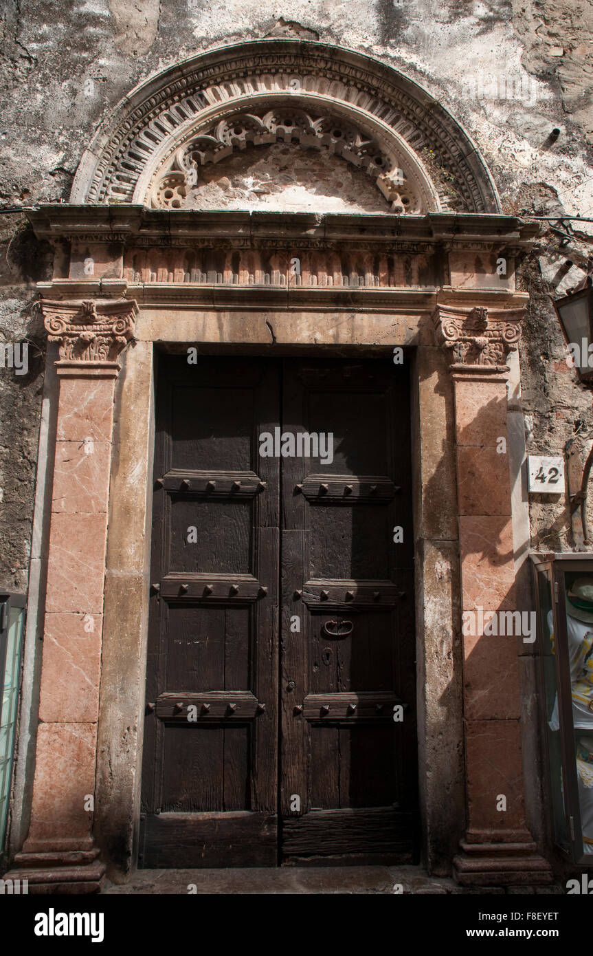 In vecchio stile di porte in legno riflettono la lunga storia di Taormina una città in Sicilia e in Italia. Foto Stock