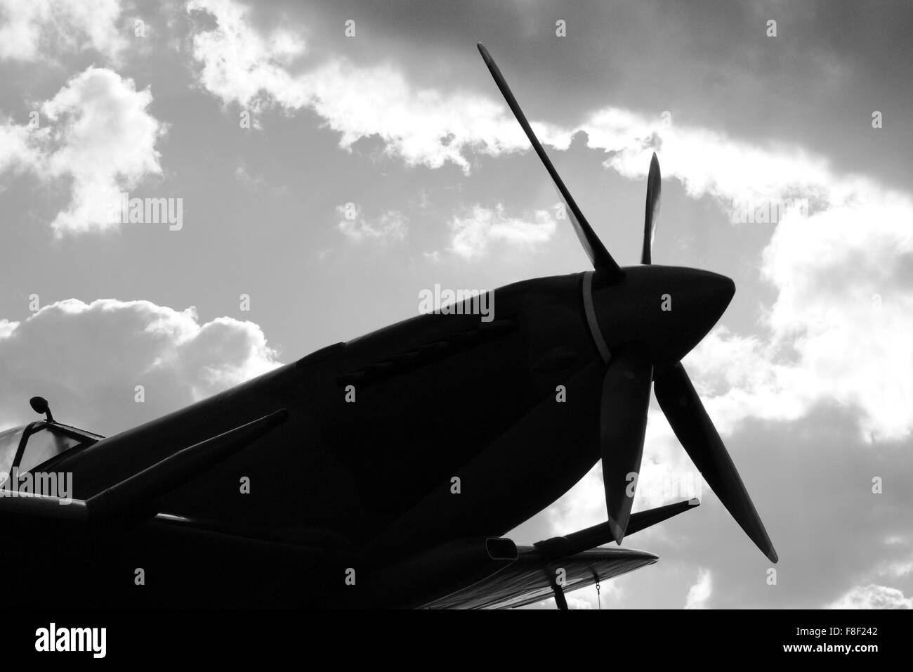 Silhouette di un Supermarine Spitfire contro un cielo blu con nuvole Foto Stock