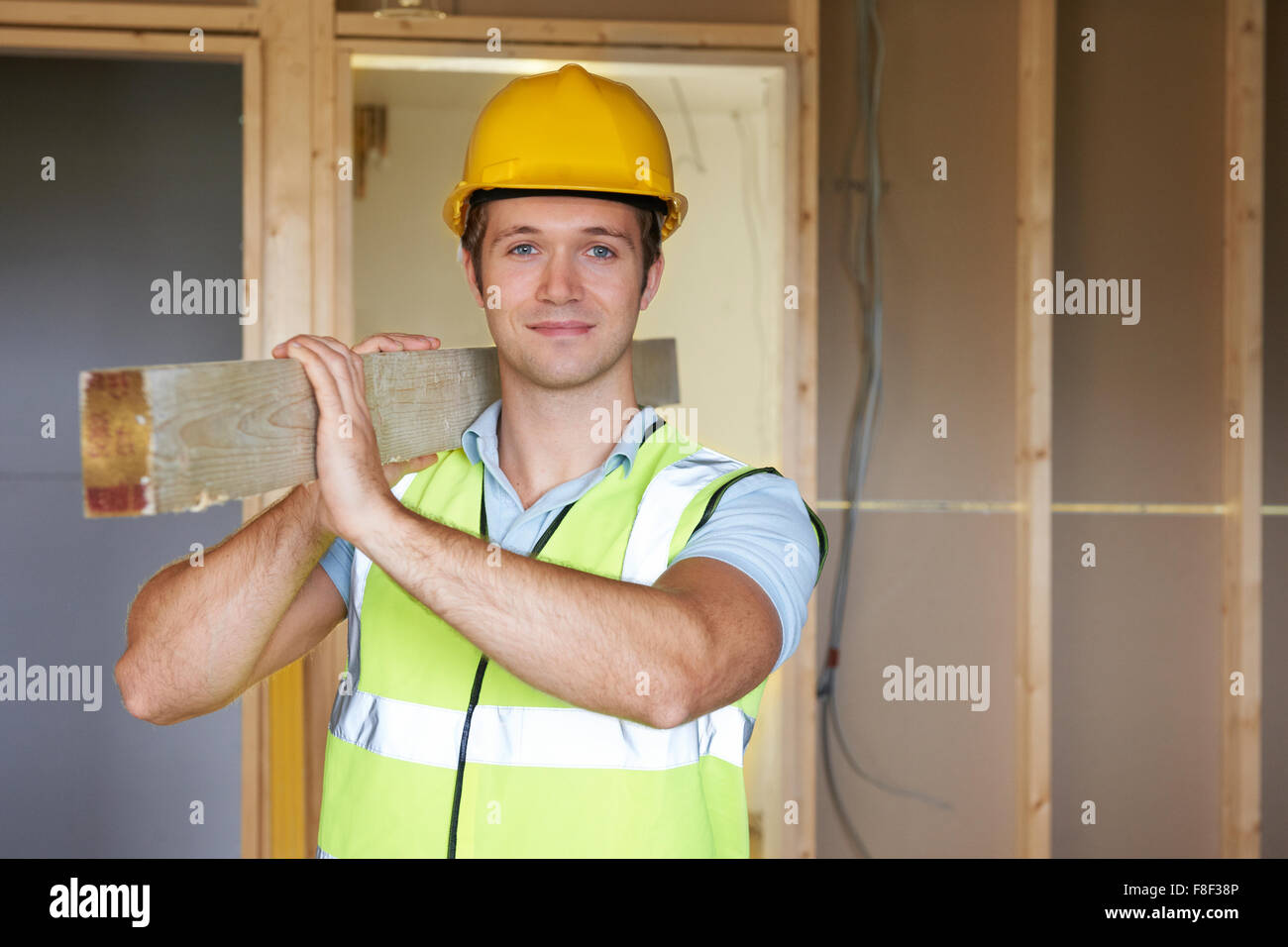 Builder che trasportano il legname sul sito di costruzione Foto Stock