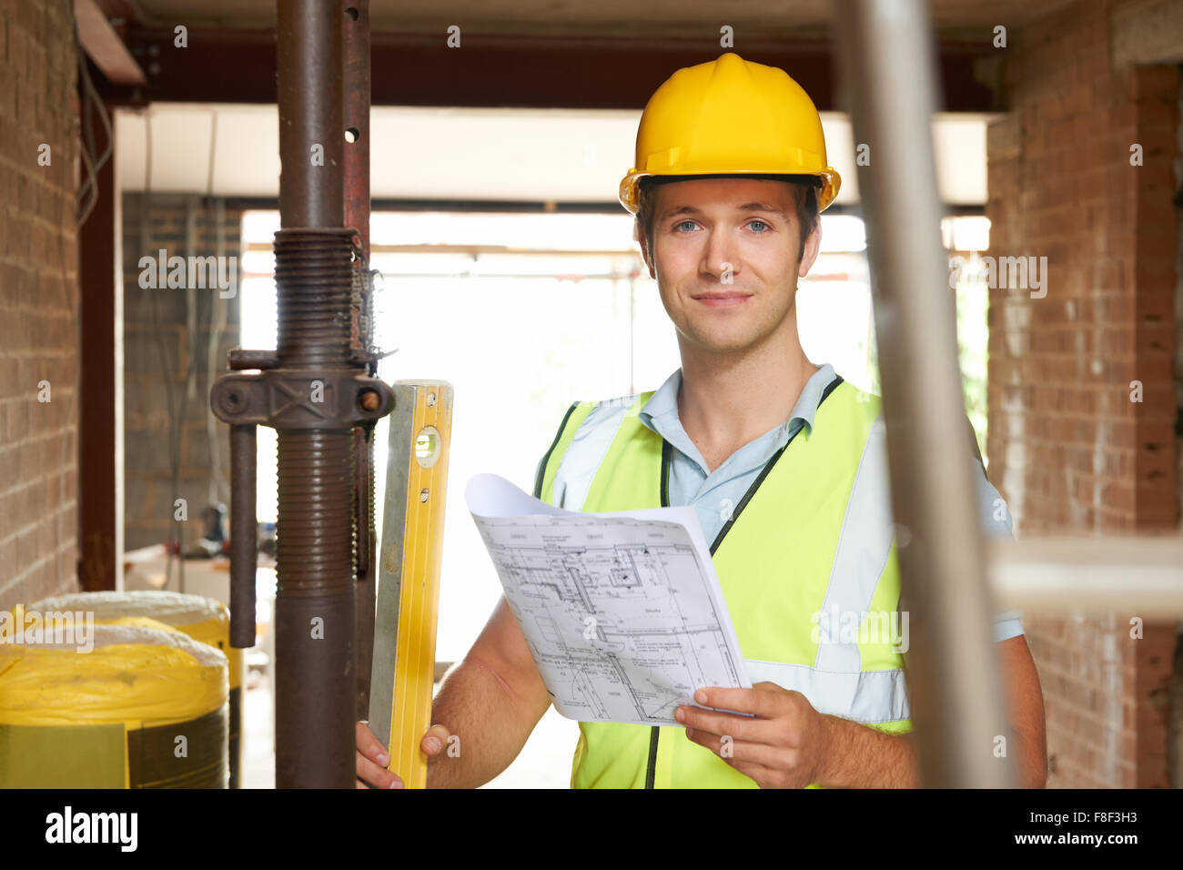 Ritratto di Builder sul sito con piani Foto Stock
