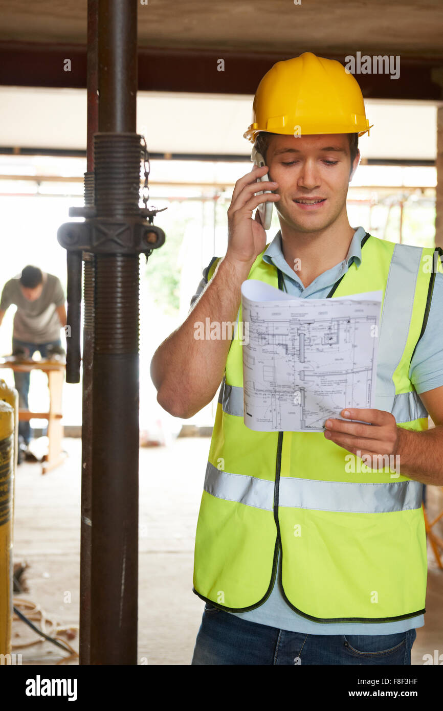 Builder sul sito usando il telefono cellulare Foto Stock