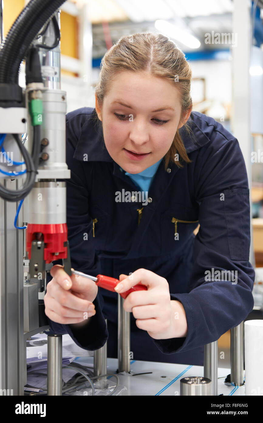 Femmina apprendista ingegnere di lavoro sulla macchina in fabbrica Foto Stock