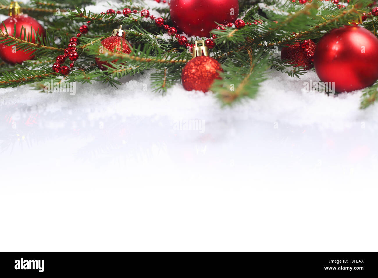 Bella rossa decorazioni di Natale e rami di abete sulla neve Foto Stock