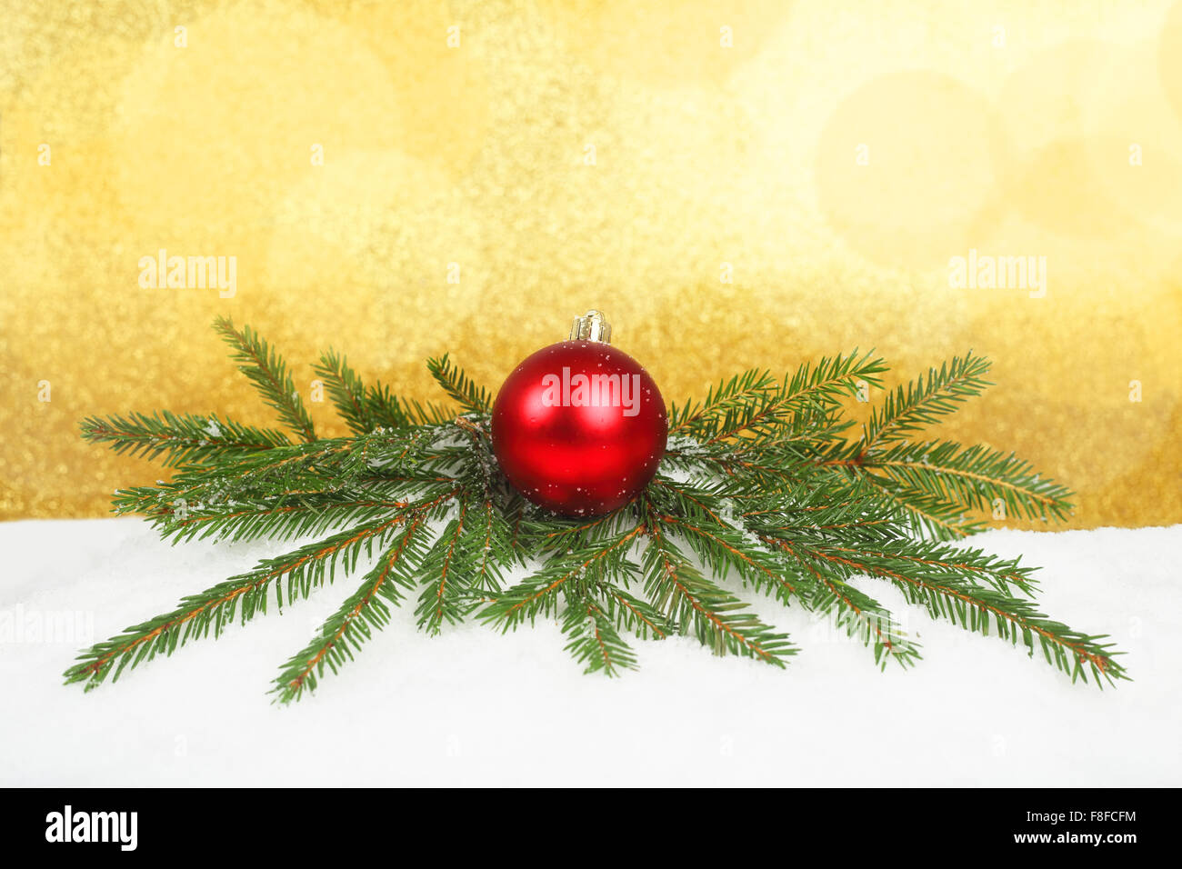 Bellissime decorazioni di Natale e rami di abete sulla neve oltre il golden sfondo bokeh di fondo Foto Stock