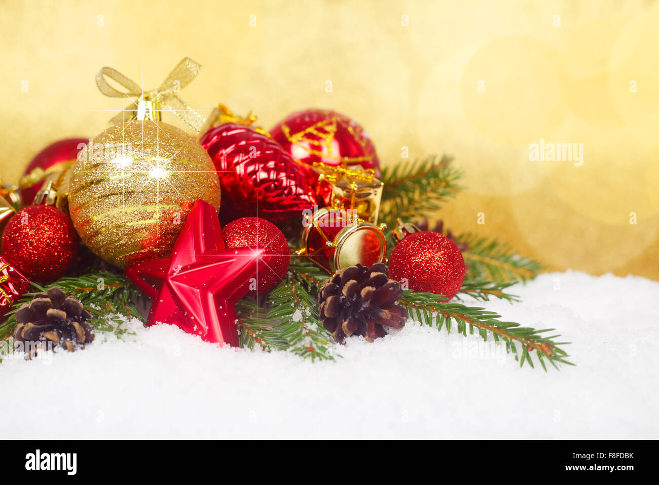 Bellissime decorazioni di Natale e rami di abete sulla neve oltre il golden sfondo bokeh di fondo Foto Stock