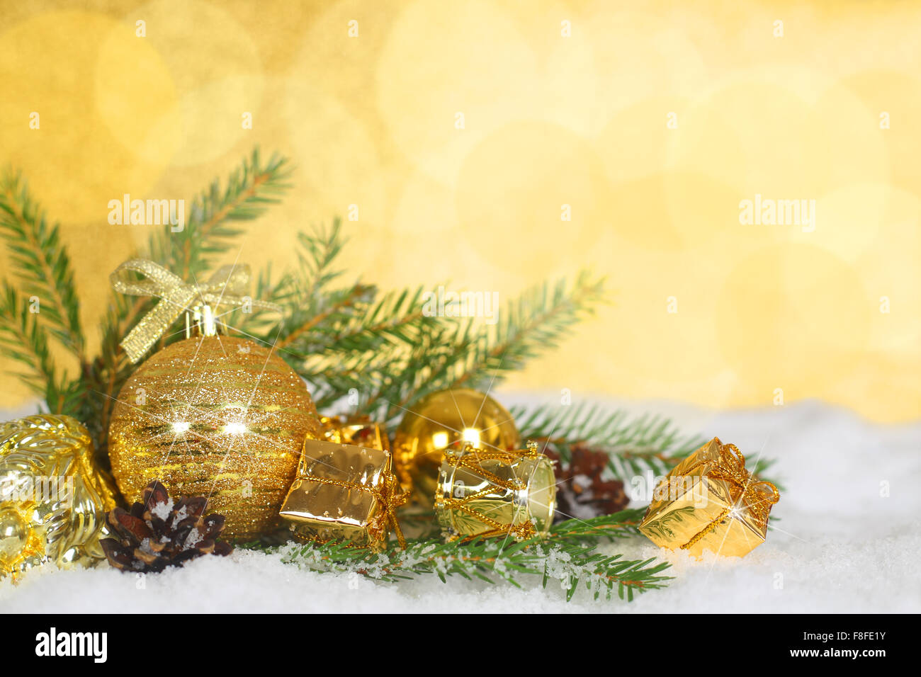 Bellissime decorazioni di Natale e rami di abete sulla neve oltre il golden sfondo bokeh di fondo Foto Stock
