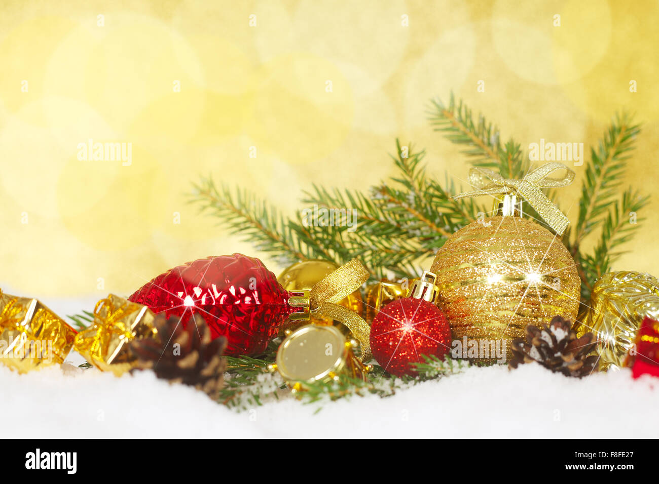 Bellissime decorazioni di Natale e rami di abete sulla neve oltre il golden sfondo bokeh di fondo Foto Stock