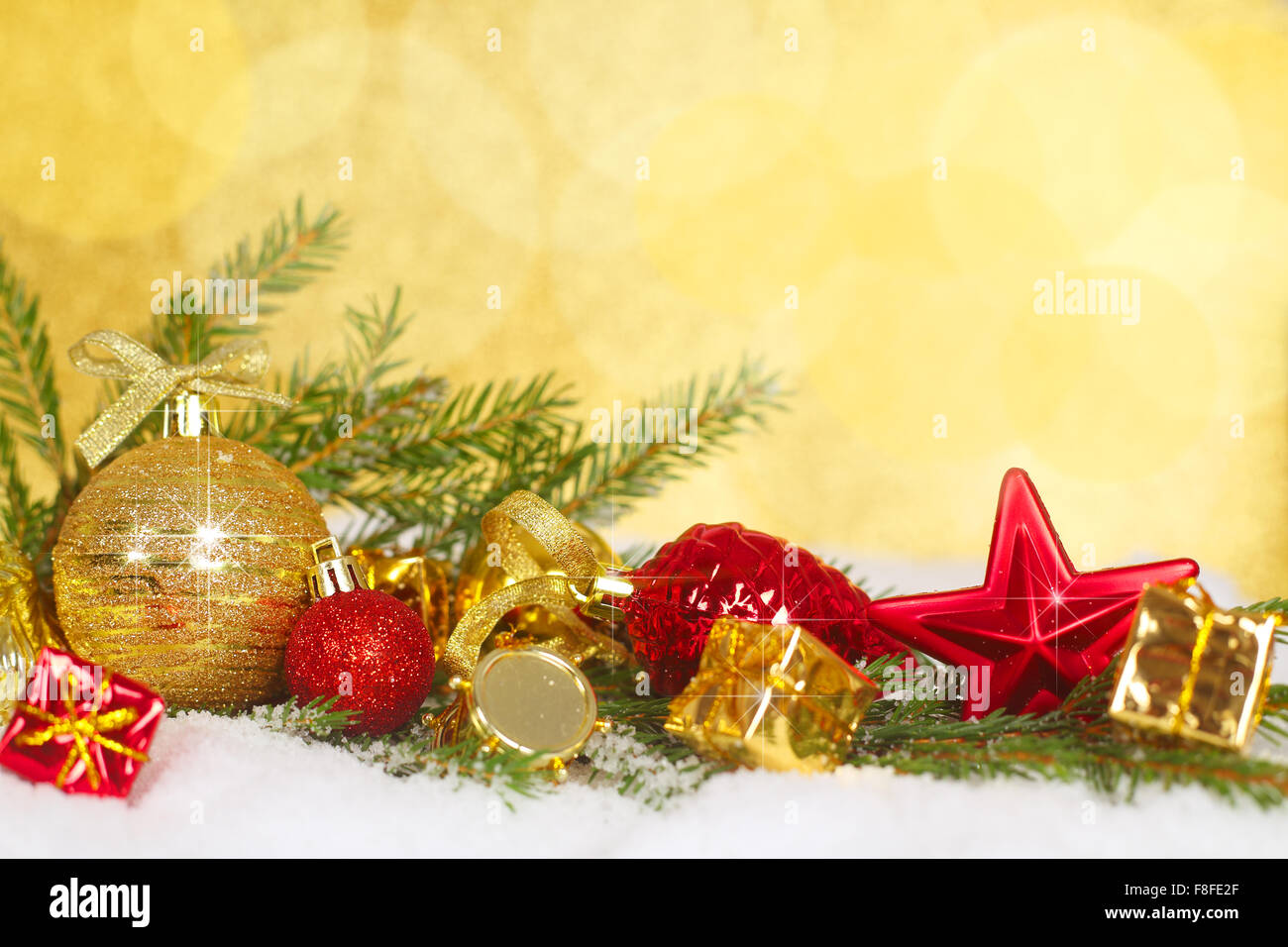 Bellissime decorazioni di Natale e rami di abete sulla neve oltre il golden sfondo bokeh di fondo Foto Stock