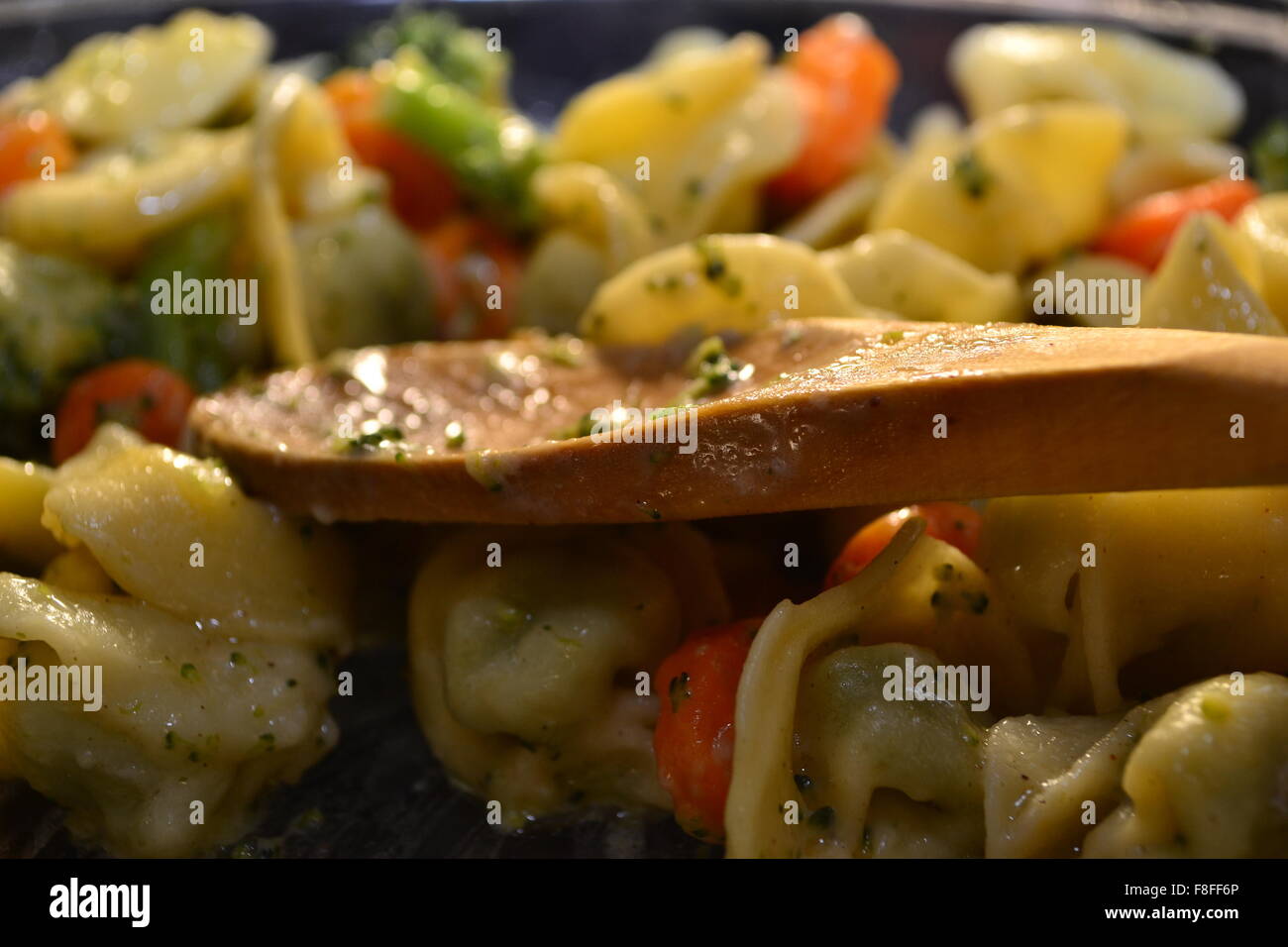 Tortellini con verdure e cucchiaio di legno Foto Stock