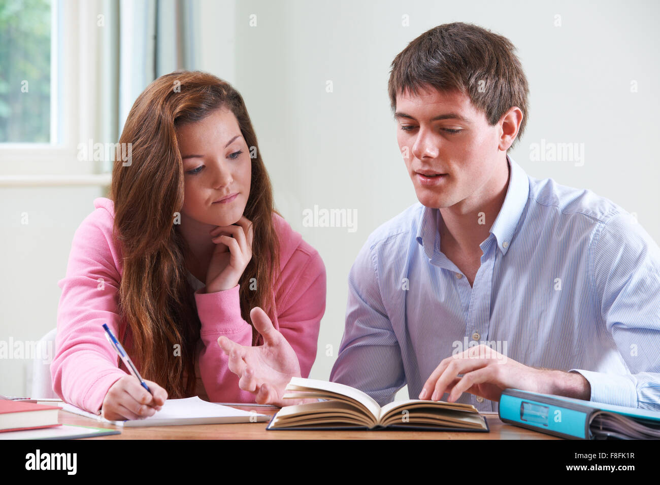 Ragazza adolescente studiando con Home Tutor Foto Stock