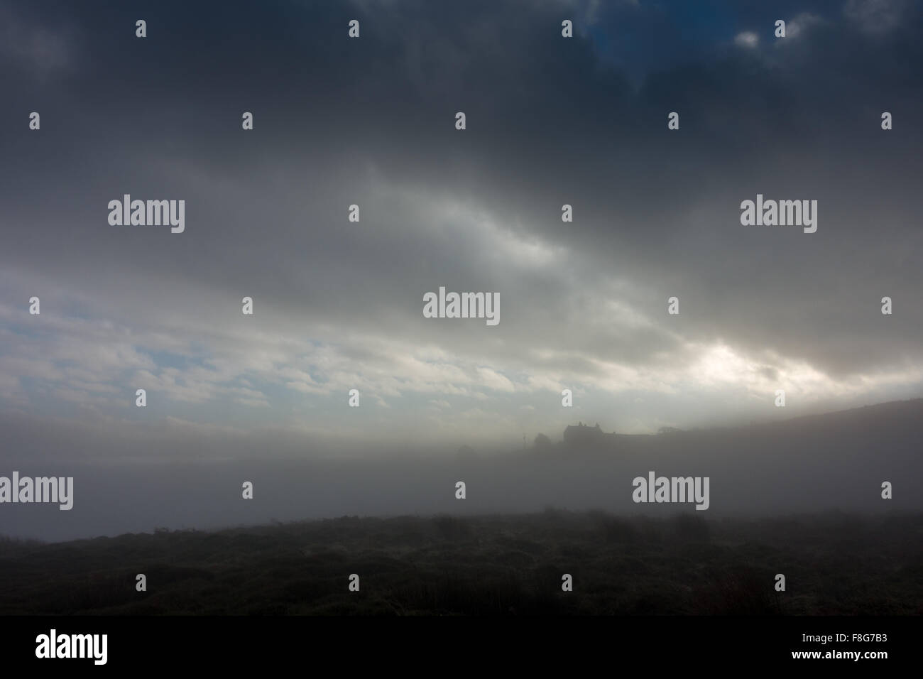Inversione di Cloud dà una sensazione inquietante di Mori con una casa in alto sulla collina immersa nella foschia Foto Stock