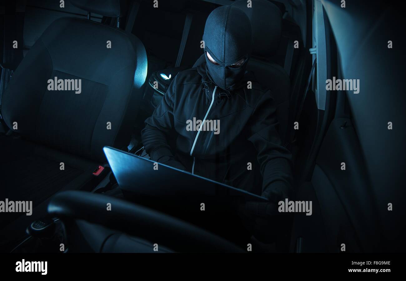 Hacking di sistemi per auto. Hacker con il suo computer al lavoro. Foto Stock