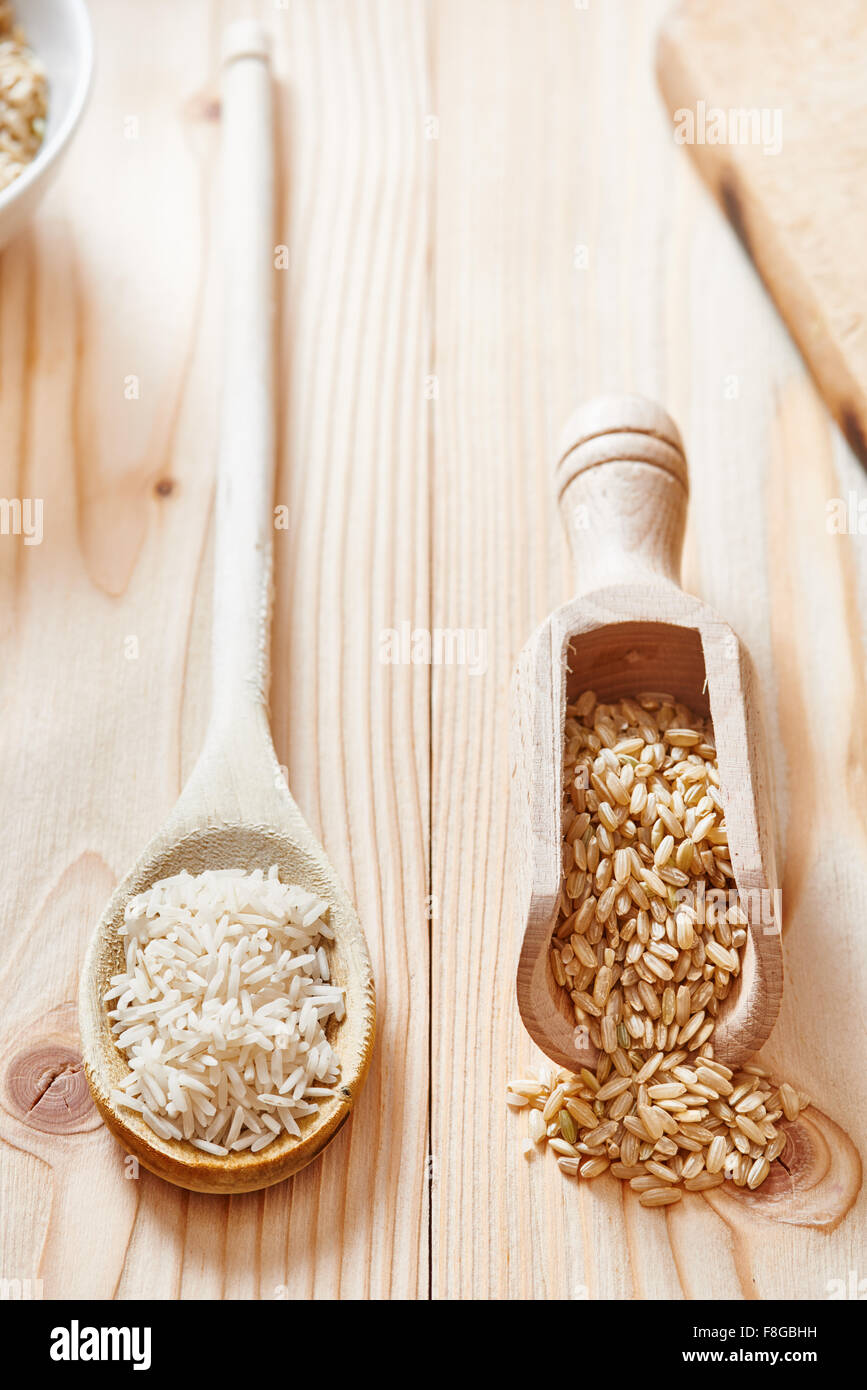 Riso Basmati e riso marrone sul cucchiaio collocato sulla luce tavolo in legno Foto Stock Riso Basmati e riso marrone sul cucchiaio collocato sulla luce tavolo in legno Foto Stock