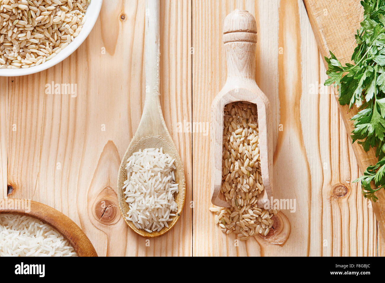 Riso Basmati e riso marrone sul cucchiaio collocato sulla luce tavolo in legno Foto Stock Riso Basmati e riso marrone sul cucchiaio collocato sulla luce tavolo in legno Foto Stock