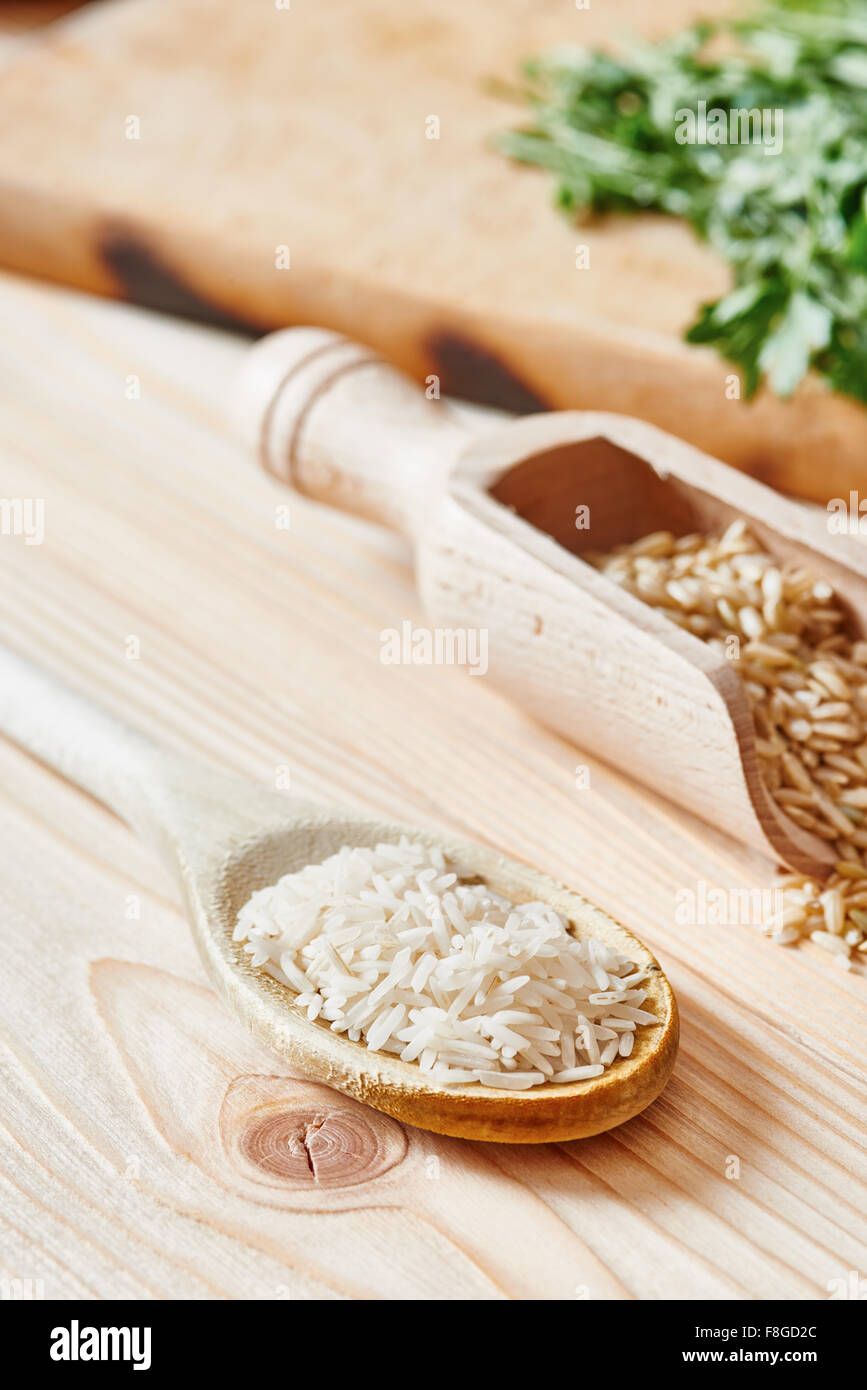 Riso Basmati e riso marrone sul cucchiaio collocato sulla luce tavolo in legno Foto Stock Riso Basmati e riso marrone sul cucchiaio collocato sulla luce tavolo in legno Foto Stock