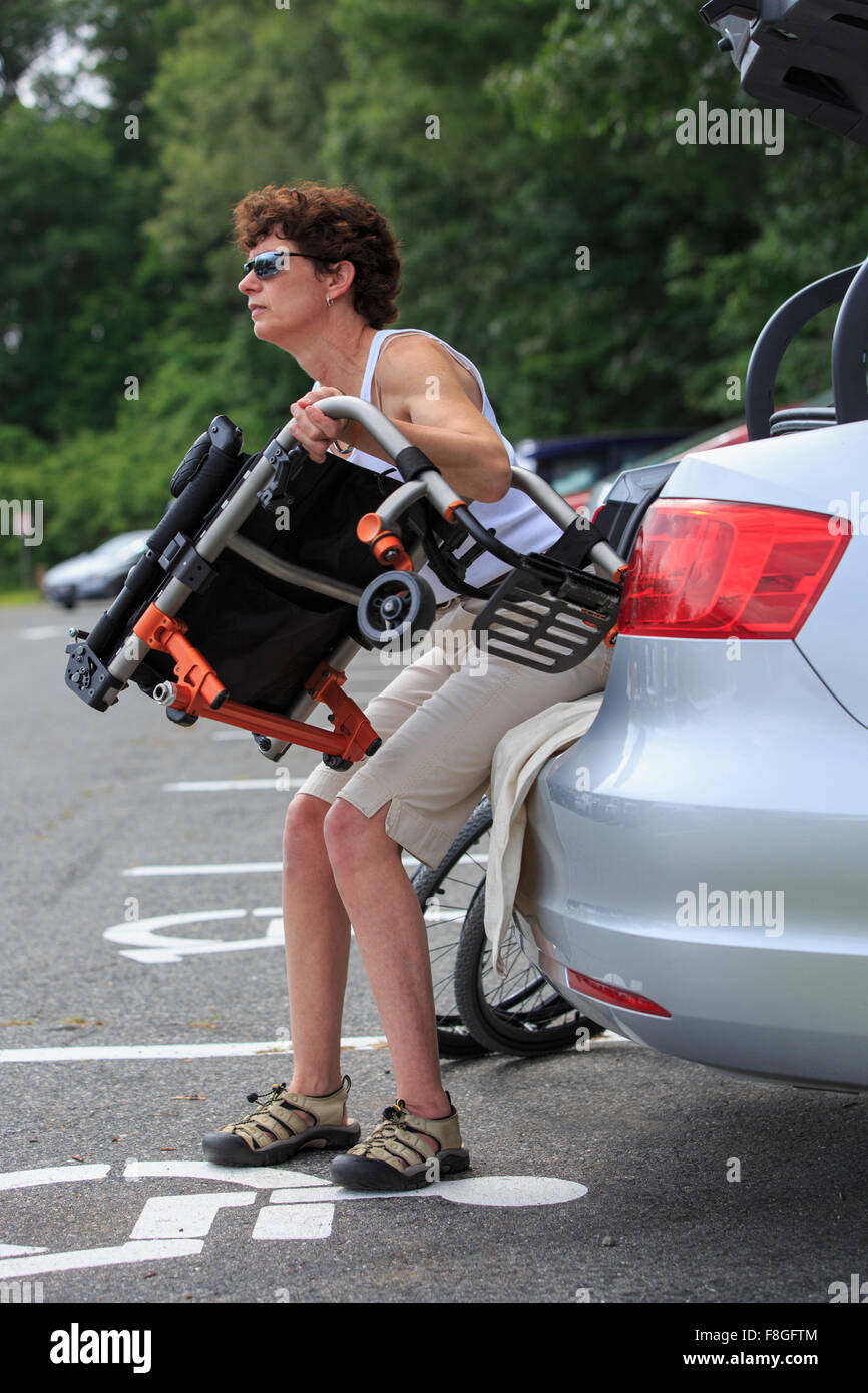 Per paraplegici caucasica donna sedia a rotelle di scarico dalla macchina Foto Stock