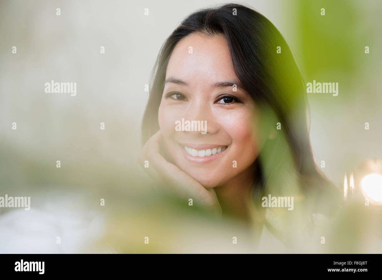 Donna cinese sorridente con mento in mano Foto Stock