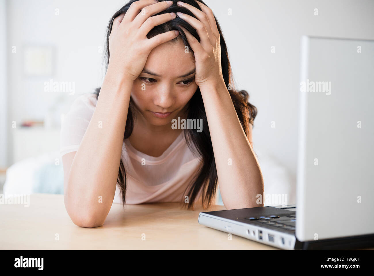Frustrati donna cinese utilizzando laptop Foto Stock