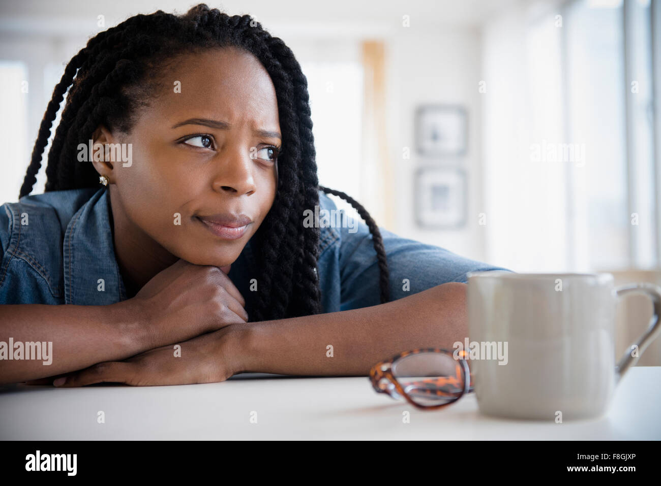 Ansiosi donna nera mento di appoggio sulle mani Foto Stock