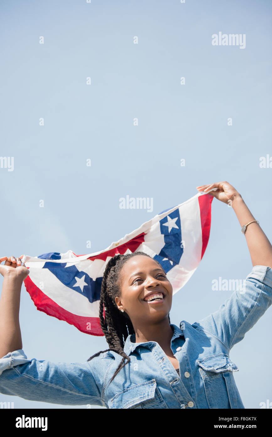 Nero donna che porta bandiera americana banner Foto Stock