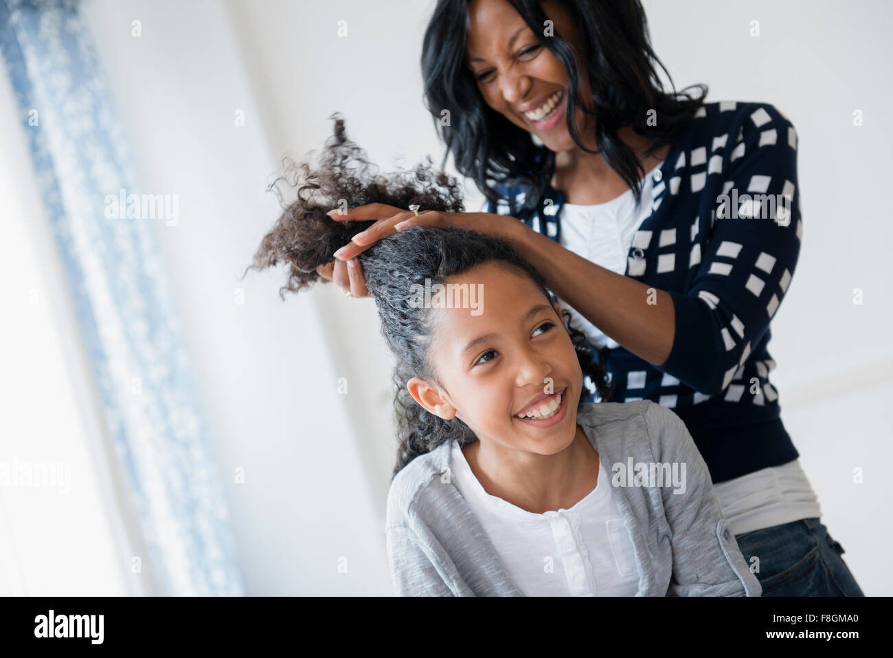Madre per lo styling dei capelli della figlia Foto Stock