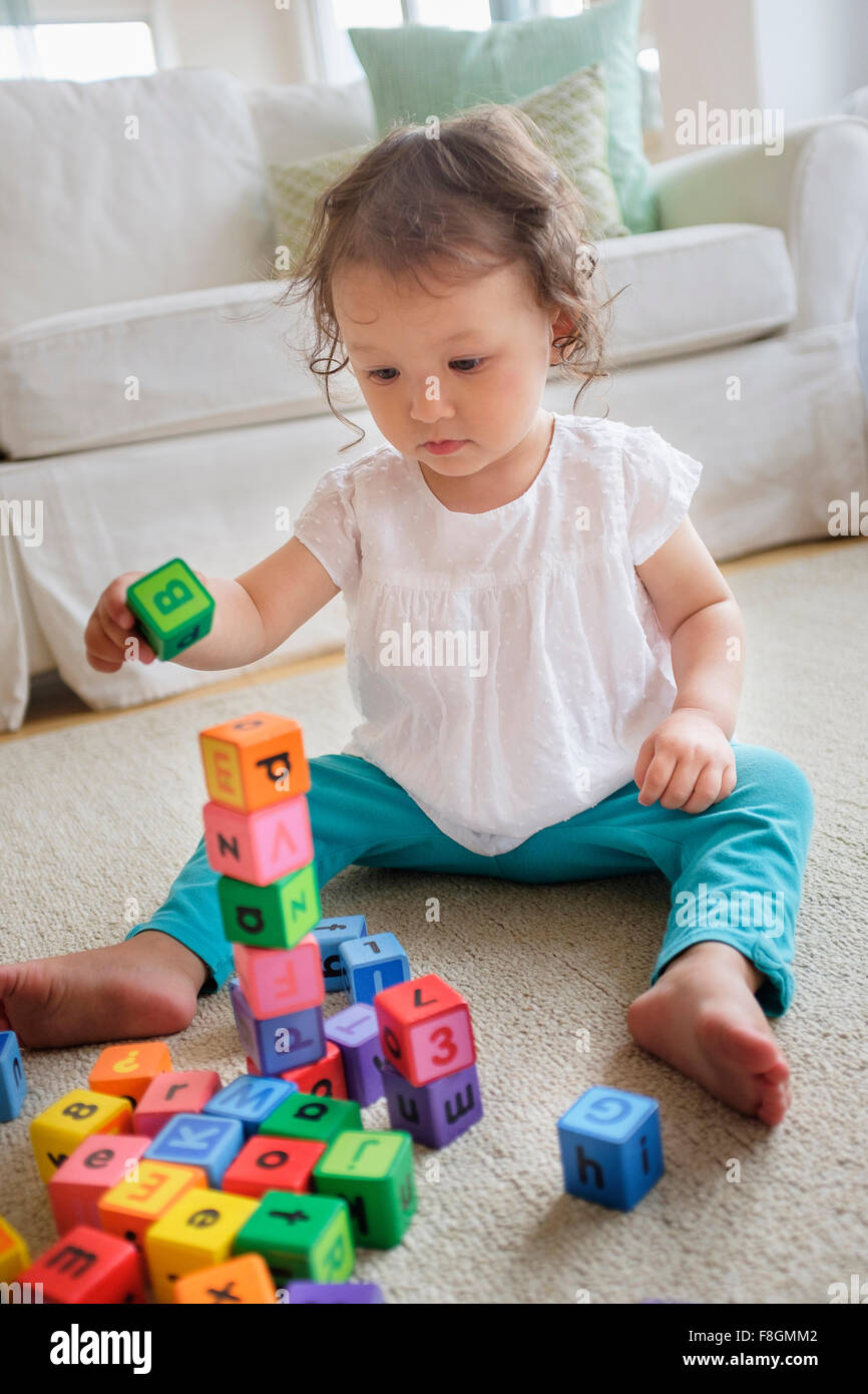 Razza mista bambina gioca con blocchi Foto Stock
