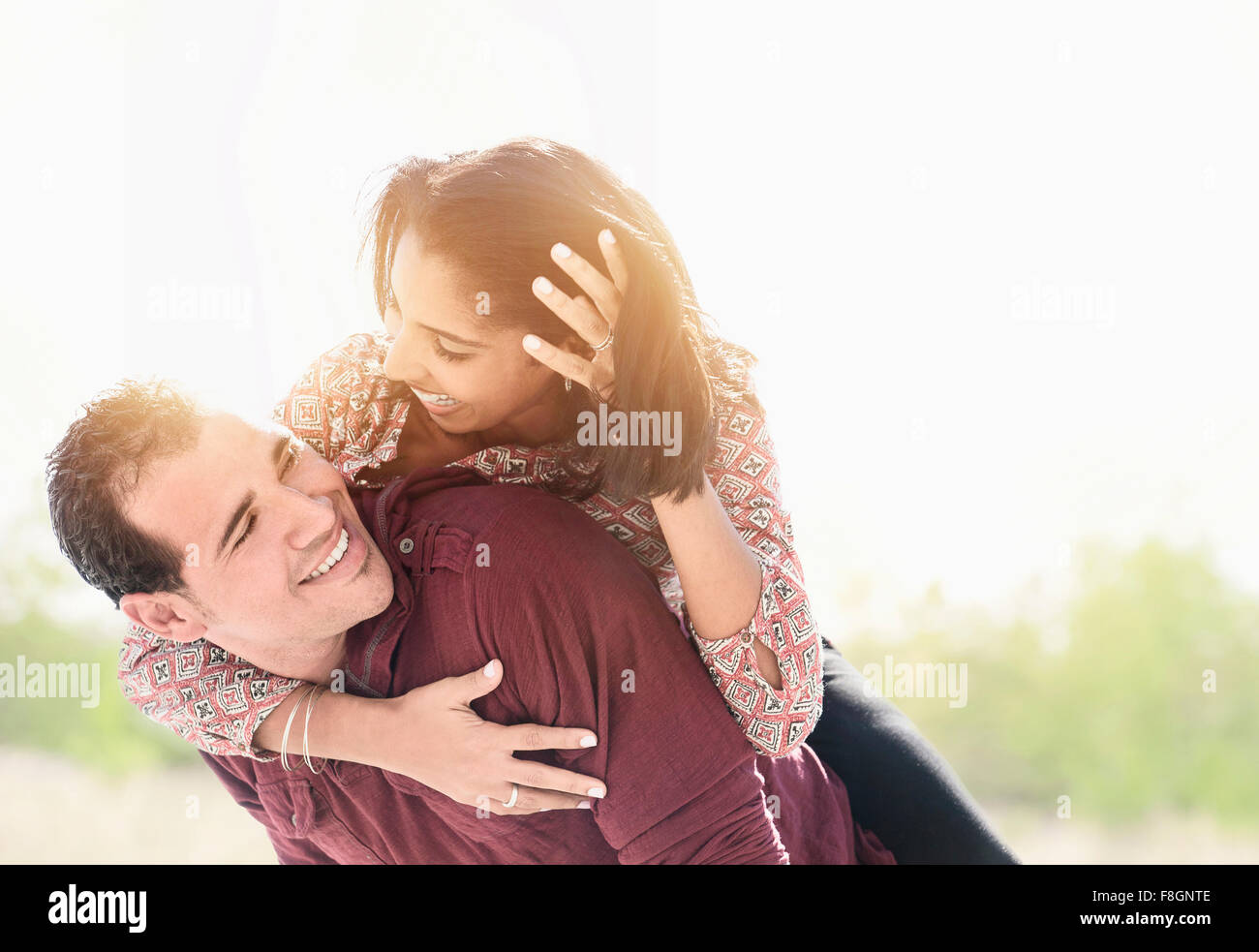 Uomo ispanico che trasportano ragazza piggyback Foto Stock