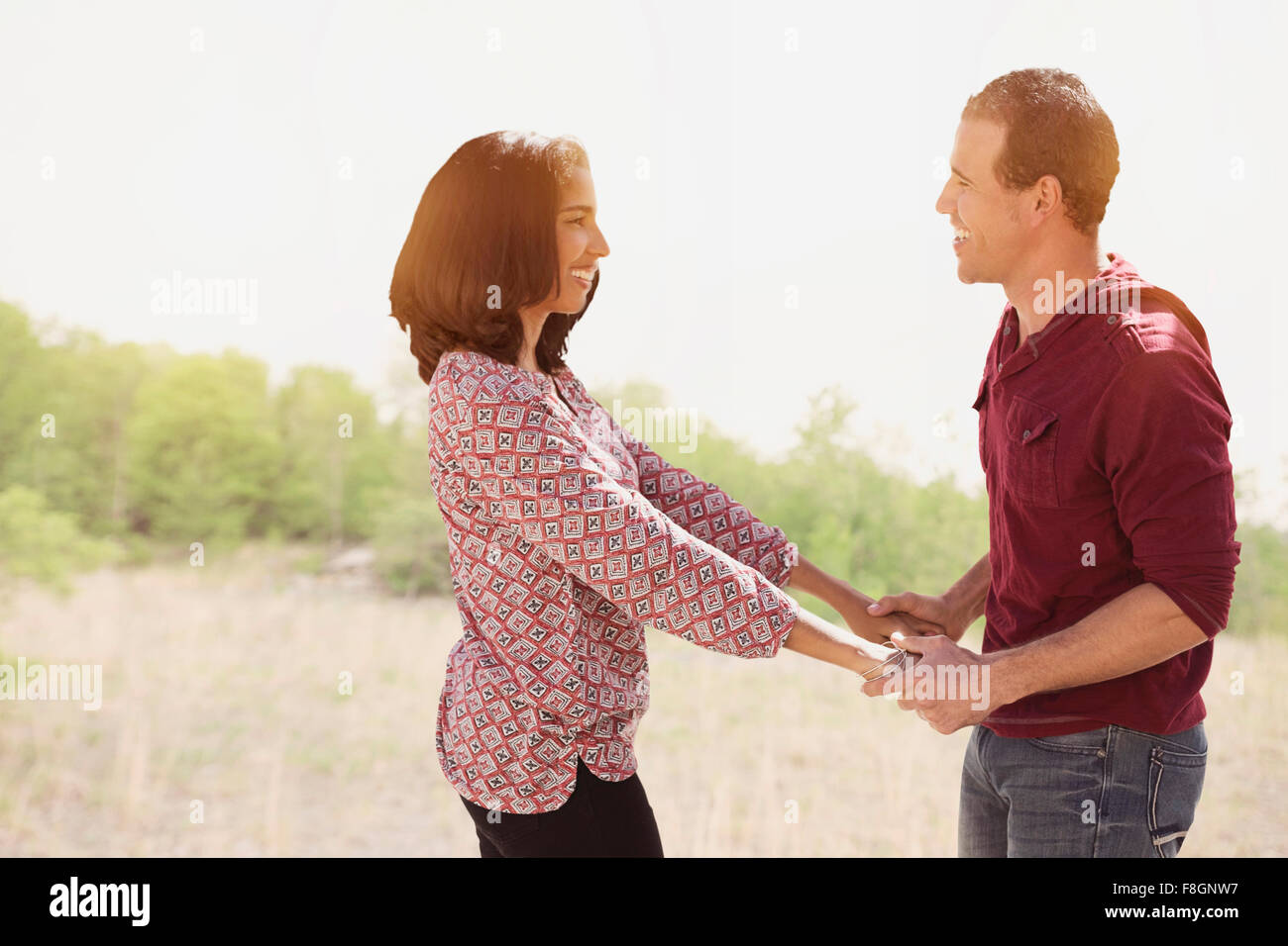 Coppia ispanica tenendo le mani all'aperto Foto Stock