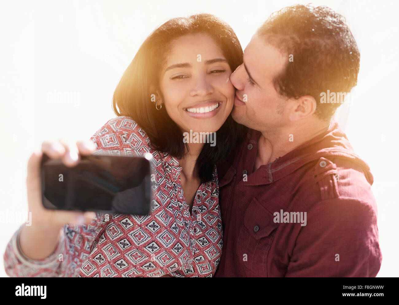 Coppia ispanica tenendo selfie all'aperto Foto Stock
