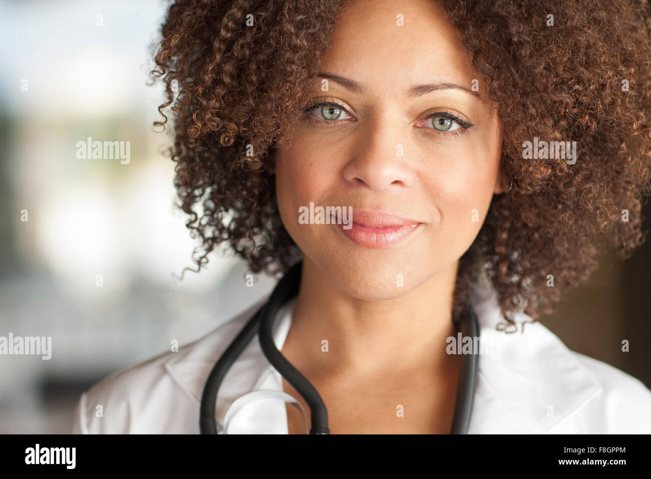 Close up di razza mista medico sorridente Foto Stock