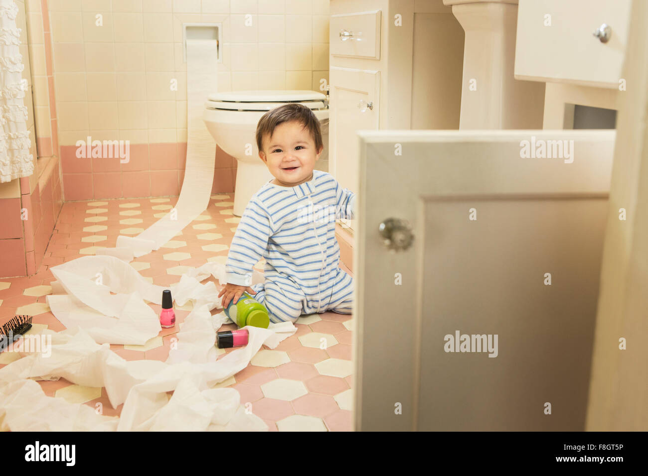 Baby boy giocando in bagno disordinati Foto Stock