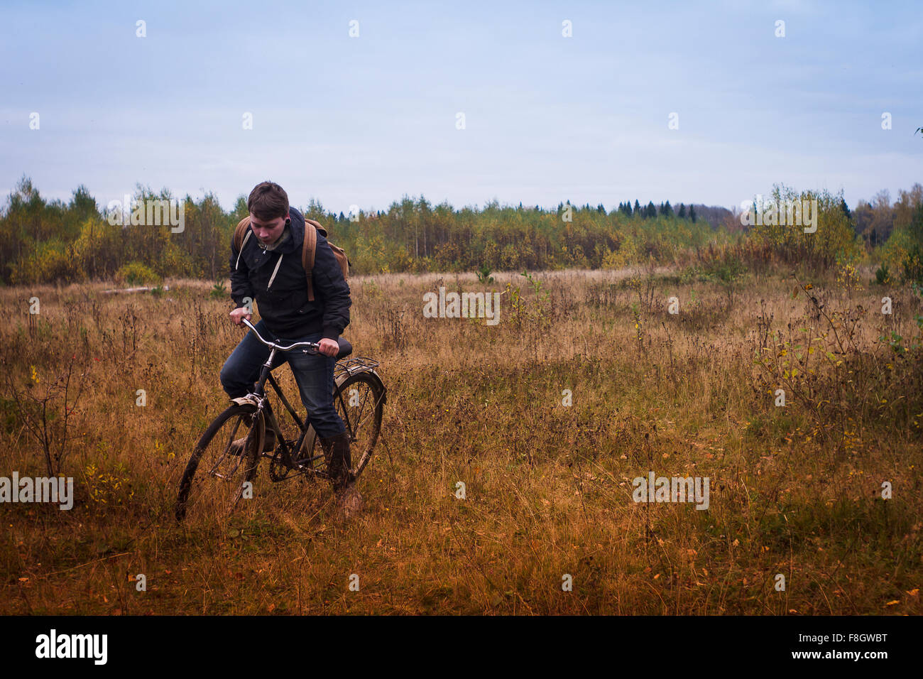 Uomo caucasico bicicletta equitazione nel campo Foto Stock