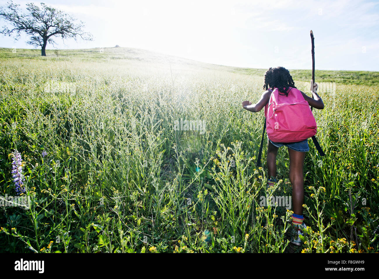 Nero ragazza camminare sulla collina rurale Foto Stock