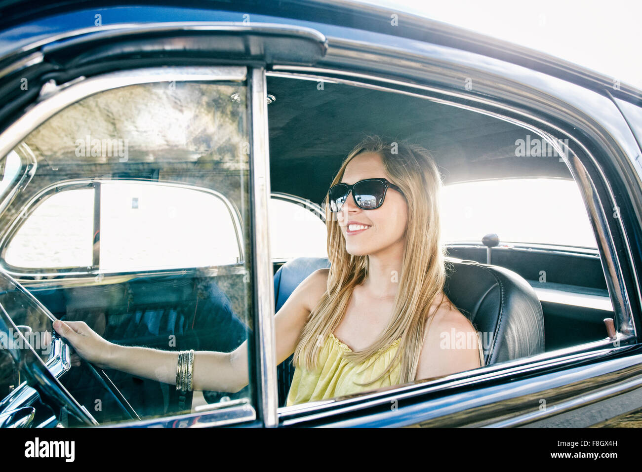 Caucasian donna alla guida di auto d'epoca Foto Stock